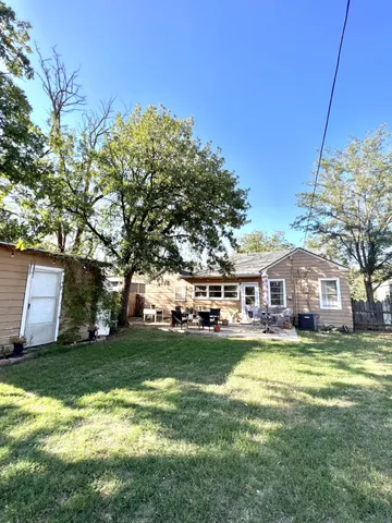 a view of a house with a big yard and large trees