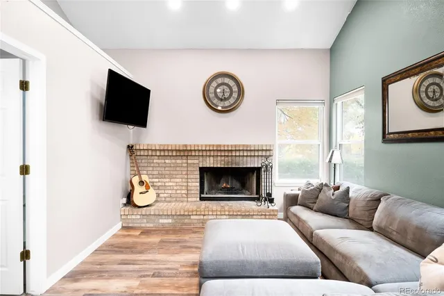 a living room with furniture a fireplace and a flat screen tv