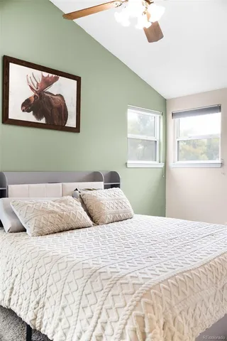 a bedroom with a large bed and a painting on the wall