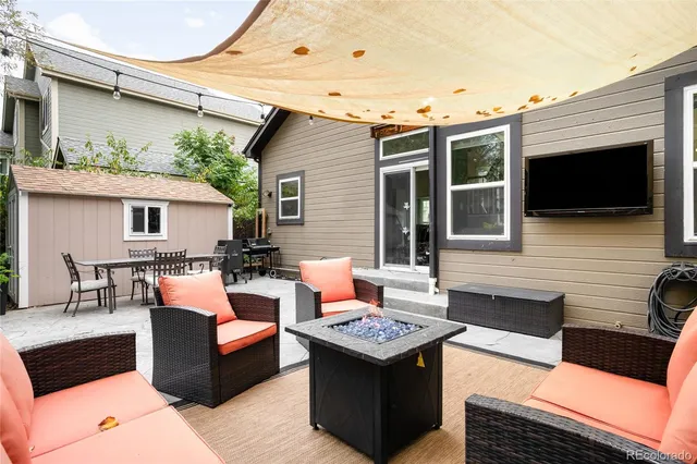 a outdoor living space with patio furniture and a flat screen tv