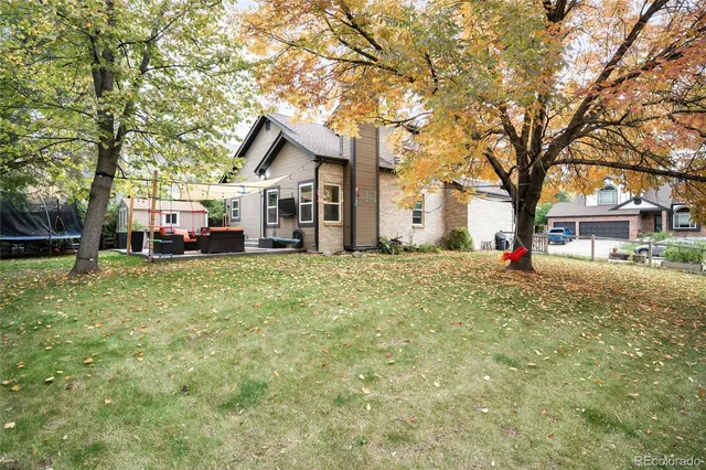 a front view of a house with a yard covered with trees