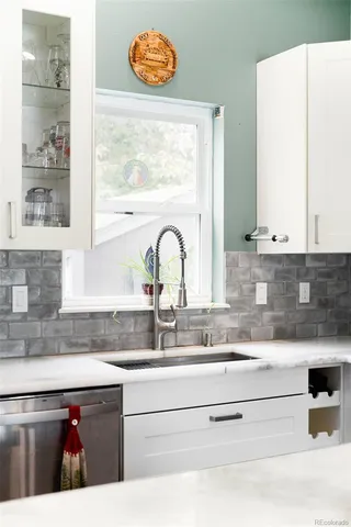 a sink with a granite counter top and a window