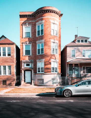 a front view of a building with lot of cars parked on road