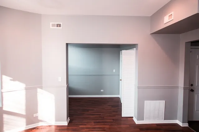 a view of empty room with wooden floor