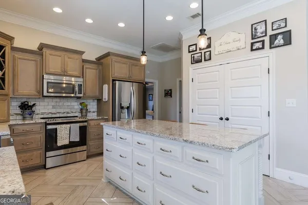 a kitchen with stainless steel appliances granite countertop a sink a stove and a refrigerator