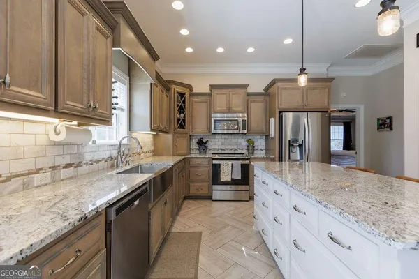 a large kitchen with granite countertop a sink and dishwasher a stove top oven with wooden floor