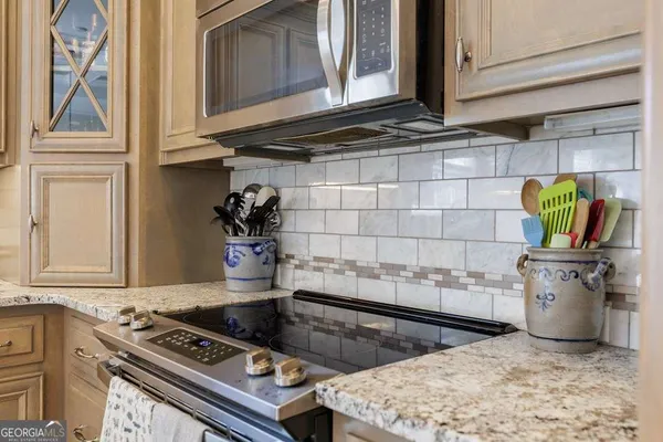 a kitchen with stainless steel appliances granite countertop a stove a sink and a microwave