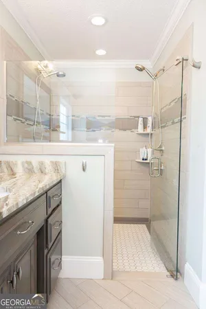 a bathroom with a granite countertop shower a mirror and a sink