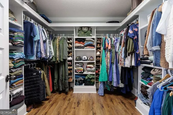a view of walk in closet with clothes and shoes