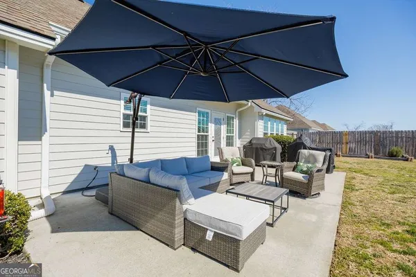 a view of an outdoor sitting area with furniture and umbrella