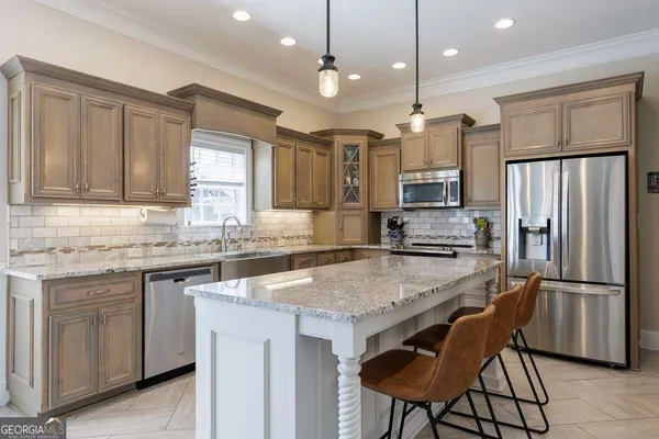 a kitchen with granite countertop a table chairs stainless steel appliances and cabinets
