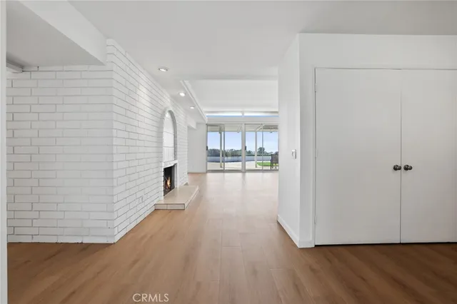 a view of a living room hardwood floor and a kitchen with wooden floor