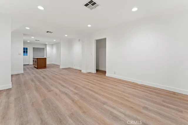 a kitchen with stainless steel appliances a dining table chairs and stove