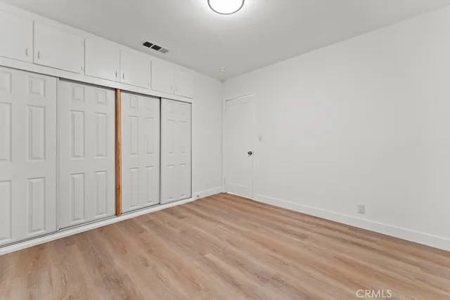 a large bed sitting in a bedroom next to a window with a chair