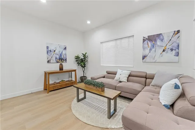 a view of empty room with wooden floor and refrigerator