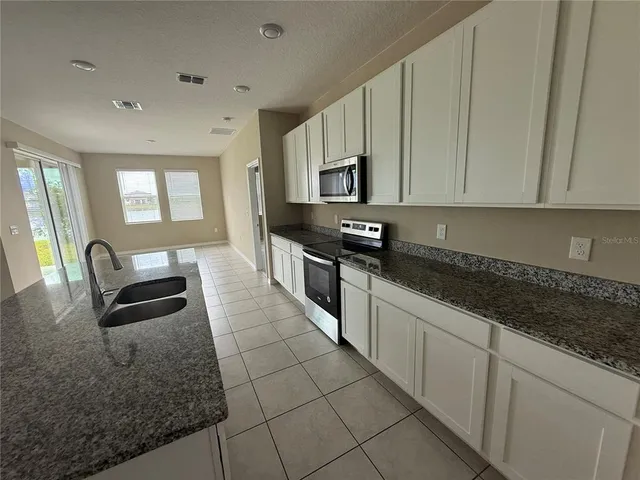 a kitchen with stainless steel appliances granite countertop a stove a sink and a granite counter tops