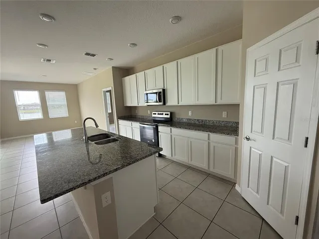 a kitchen with stainless steel appliances granite countertop a sink stove and cabinets