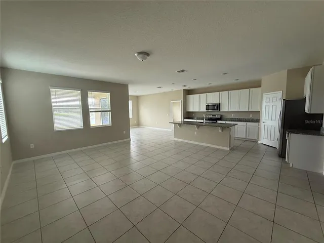 a kitchen with stainless steel appliances a stove a sink a microwave and a refrigerator