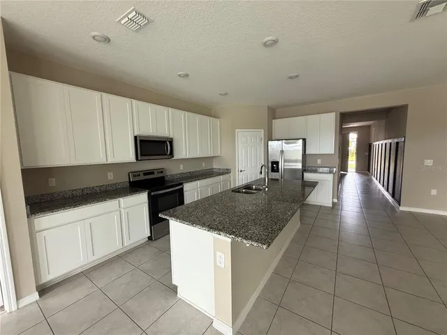 a kitchen with stainless steel appliances granite countertop a sink dishwasher stove top oven and cabinets