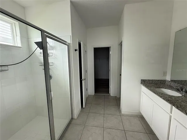 a bathroom with a granite countertop sink and shower