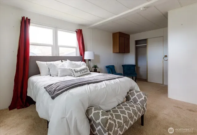 a spacious bedroom with a bed and a chair