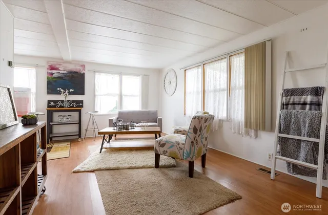 a living room with furniture a rug and a floor to ceiling window