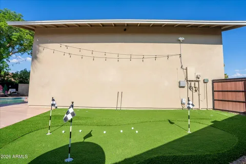 a kitchen with stainless steel appliances kitchen island granite countertop a refrigerator a sink dishwasher a dining table and chairs with wooden floor