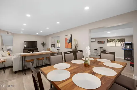 a black leather couch in a living room next to a window