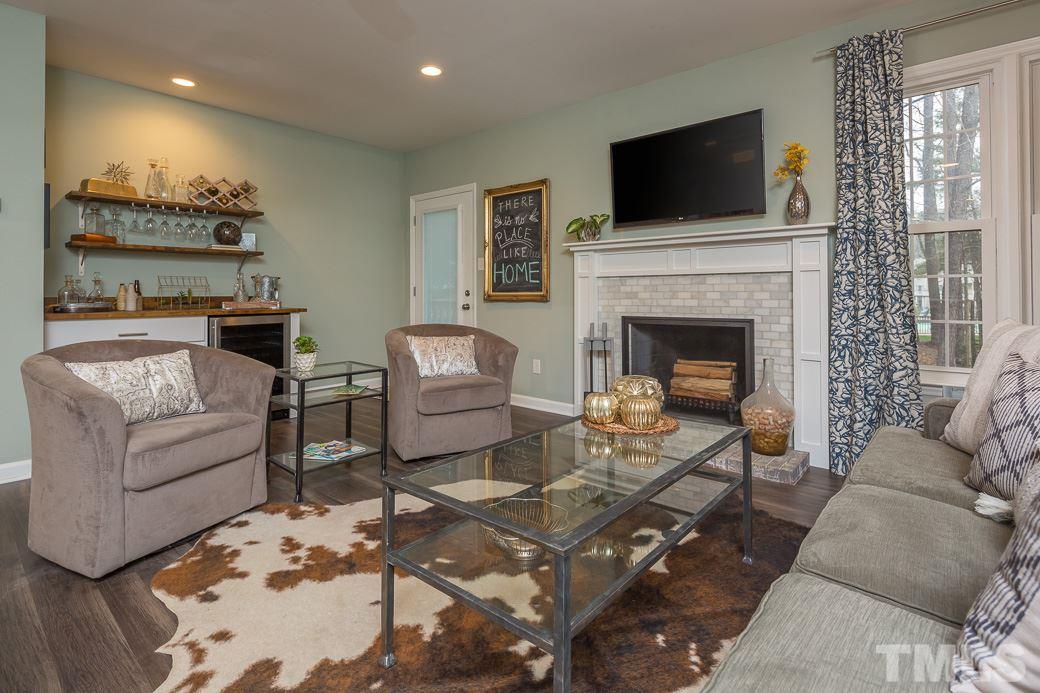 6241 Waterside Lane Raleigh, NC 27613 - Photo 3 of 16 a living room with furniture a flat screen tv and a fireplace