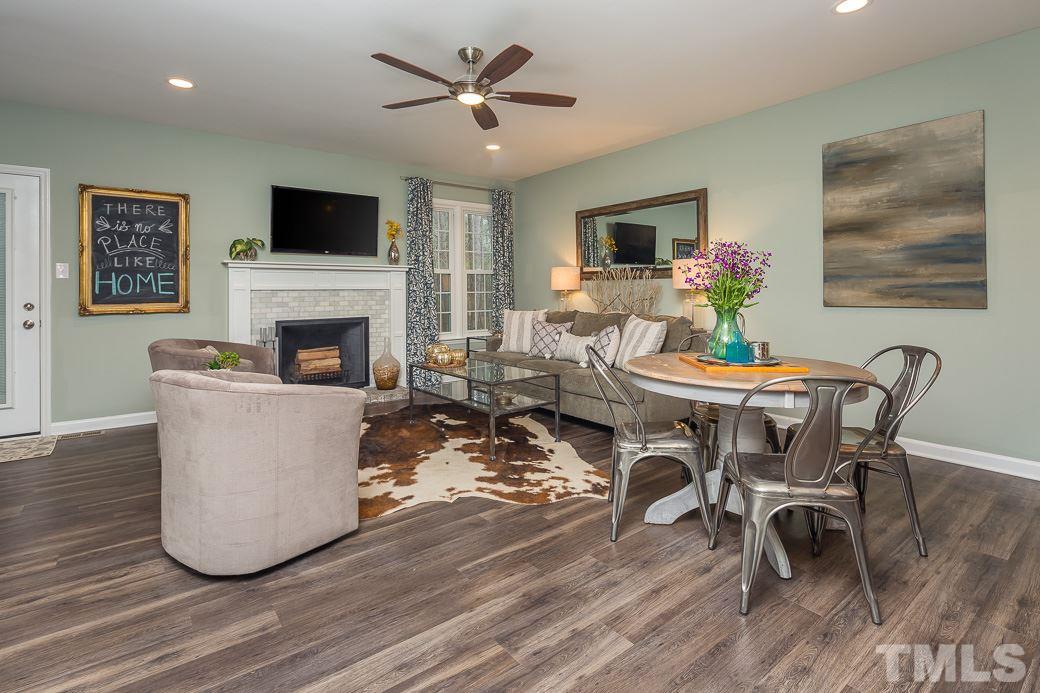 6241 Waterside Lane Raleigh, NC 27613 - Photo 4 of 16 a living room with furniture a fireplace and a flat screen tv