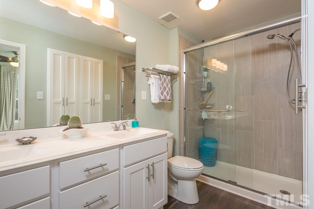 6241 Waterside Lane Raleigh, NC 27613 - Photo 7 of 16 a bathroom with a double vanity sink toilet mirror and shower