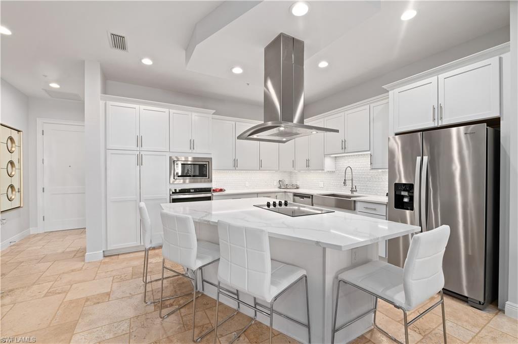 21490 Strada Nuova Circle, Unit D211 Estero, FL 33928 - Photo 1 of 45 a kitchen with stainless steel appliances a refrigerator a stove a sink a table and chairs