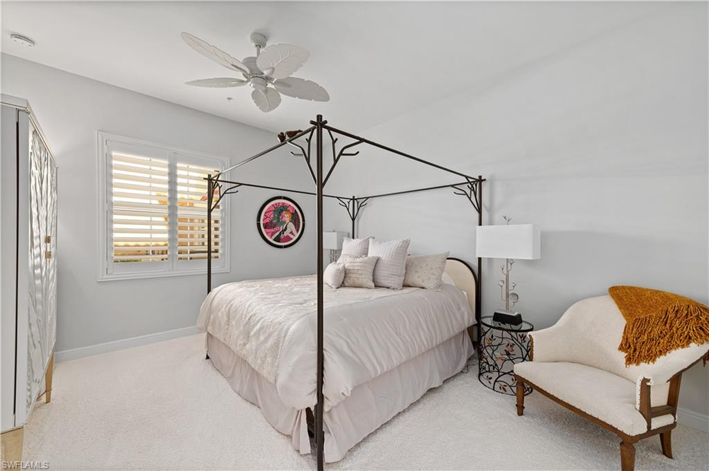 21490 Strada Nuova Circle, Unit D211 Estero, FL 33928 - Photo 17 of 45 a bedroom with a bed and a chandelier