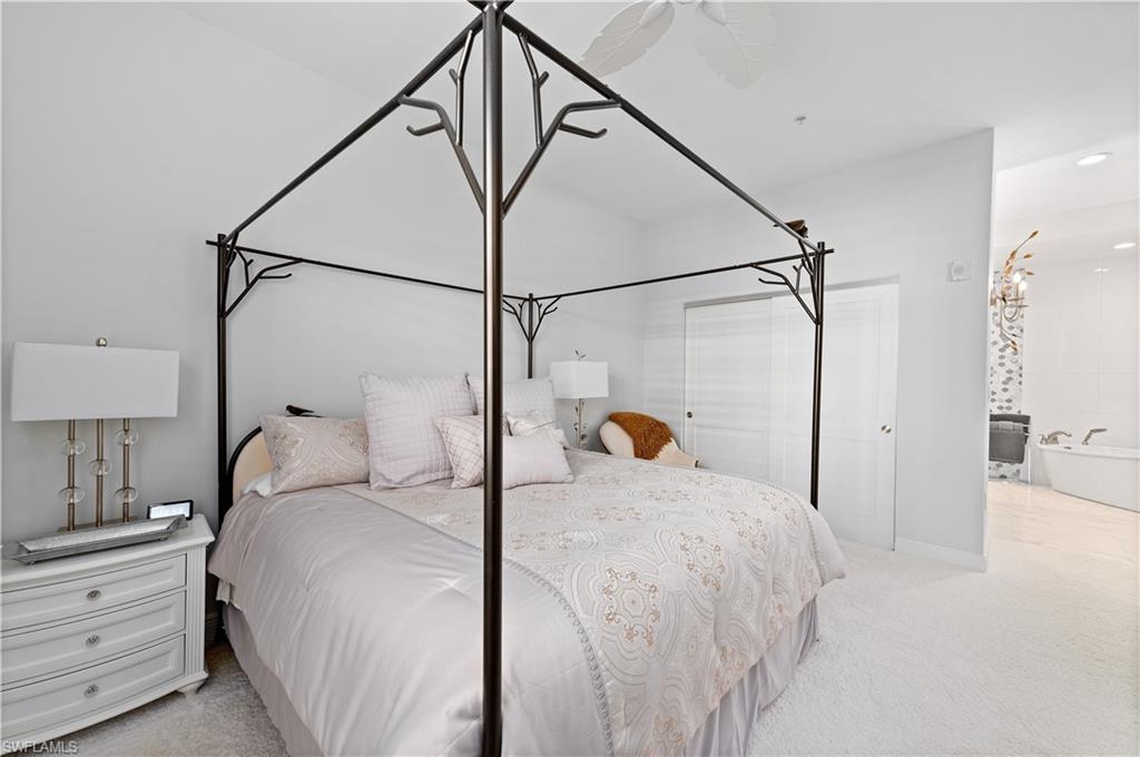 21490 Strada Nuova Circle, Unit D211 Estero, FL 33928 - Photo 19 of 45 a bedroom with a bed and a chandelier