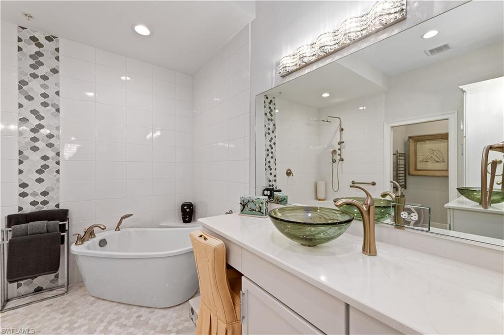 21490 Strada Nuova Circle, Unit D211 Estero, FL 33928 - Photo 21 of 45 a bathroom with a tub sink and mirror