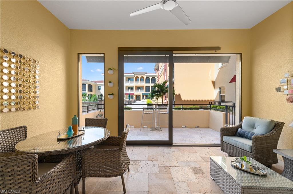 21490 Strada Nuova Circle, Unit D211 Estero, FL 33928 - Photo 30 of 45 a living room with furniture and a floor to ceiling window
