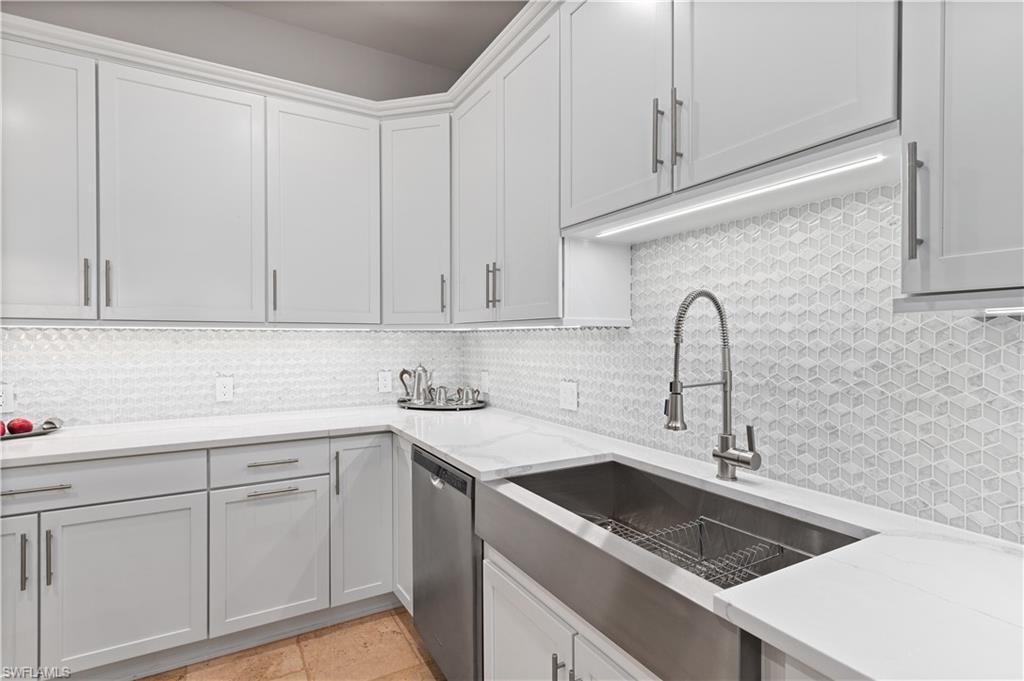 21490 Strada Nuova Circle, Unit D211 Estero, FL 33928 - Photo 4 of 45 a kitchen with white cabinets sink and dishwasher