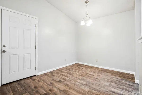 a view of a room with wooden floor and white walls