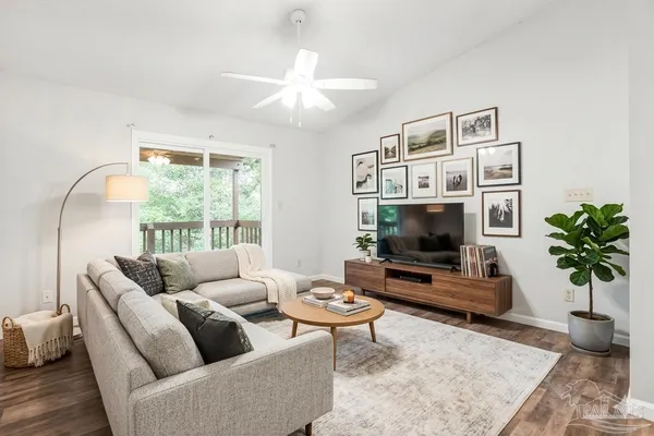 a living room with furniture a flat screen tv and a large window