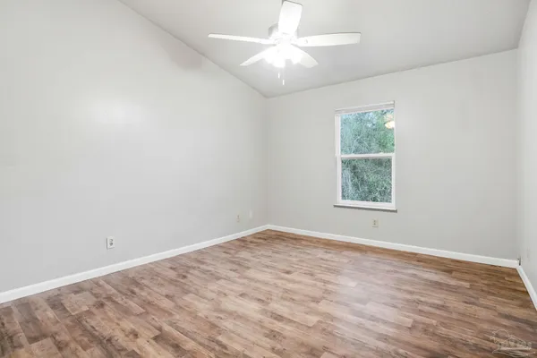 an empty room with a window and a fan