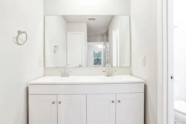 a bathroom with a double vanity sink mirror and