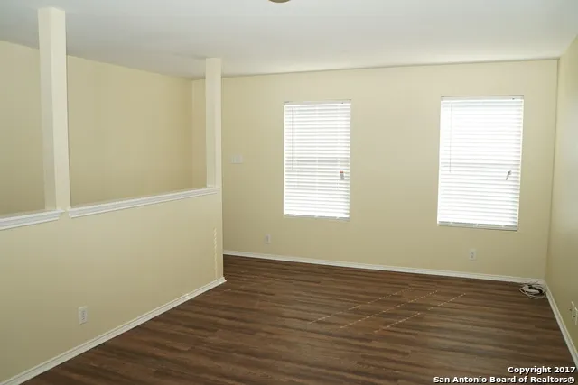 a view of a room with wooden floor and fan