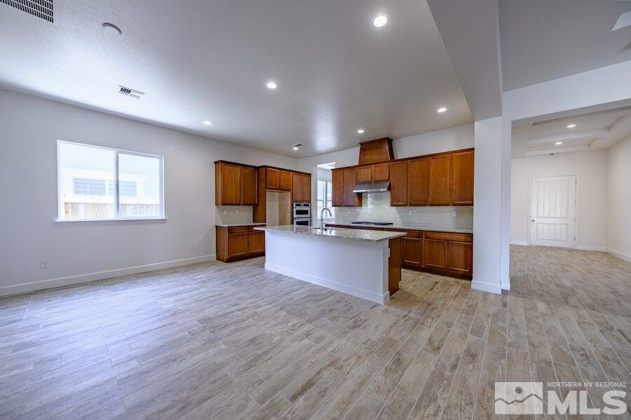 2345 Stone Rise Road, Unit SORRENTO TRAIL LOT #132 Reno, NV 89521 - Photo 6 of 11 a kitchen with stainless steel appliances kitchen island wooden cabinets and granite counter tops