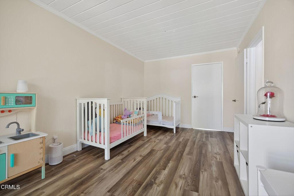 1213 Nilgai Place Ventura, CA 93003 - Photo 13 of 22 a view of a room with baby crib lounge chair and a fireplace
