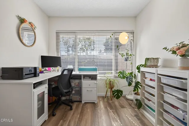 a view of a workspace with furniture and a window