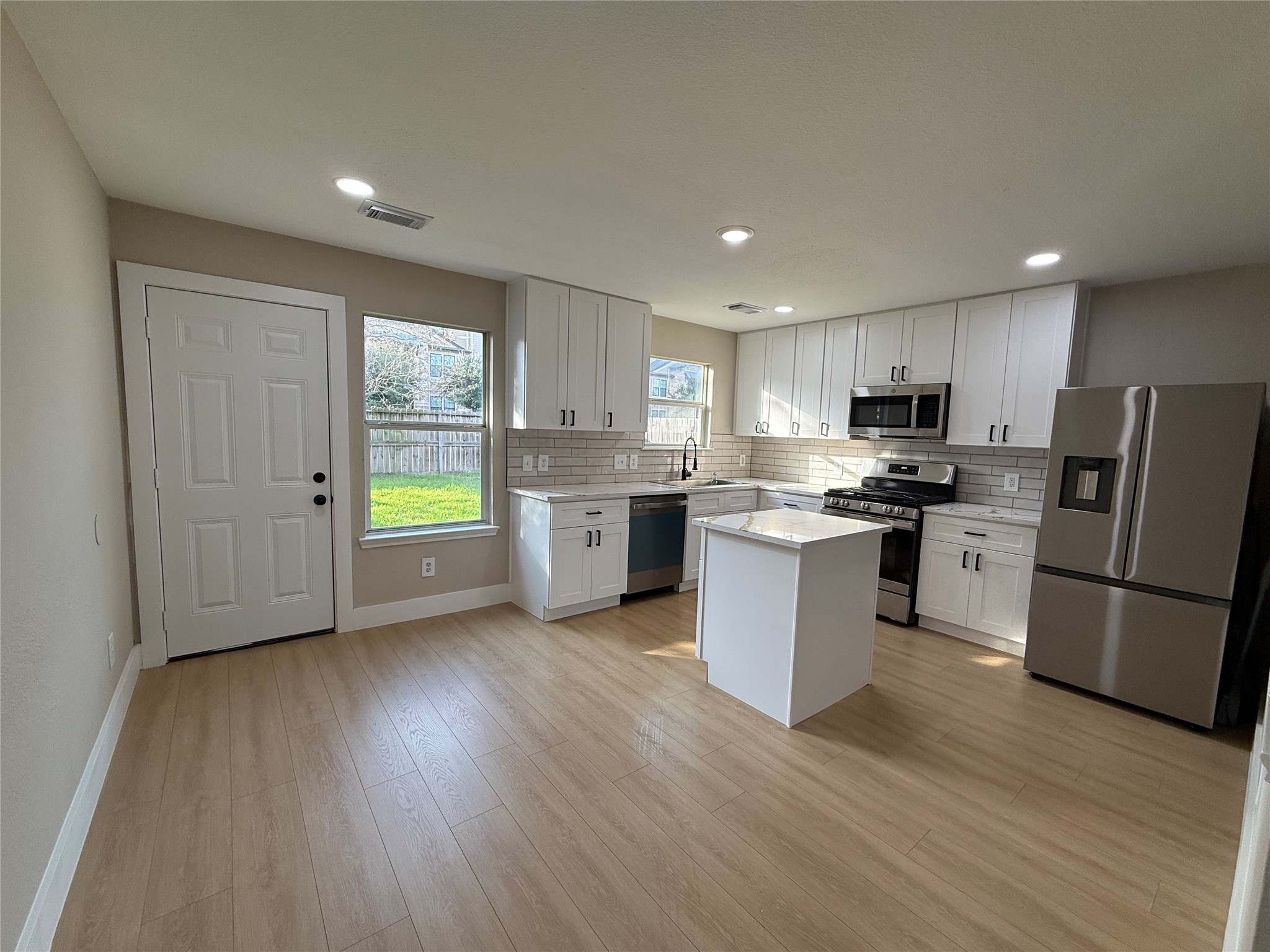 3819 Banks Ridge Lane Katy, TX 77449 - Photo 4 of 19 a kitchen with stainless steel appliances granite countertop a refrigerator a stove top oven a sink and dishwasher with wooden floor