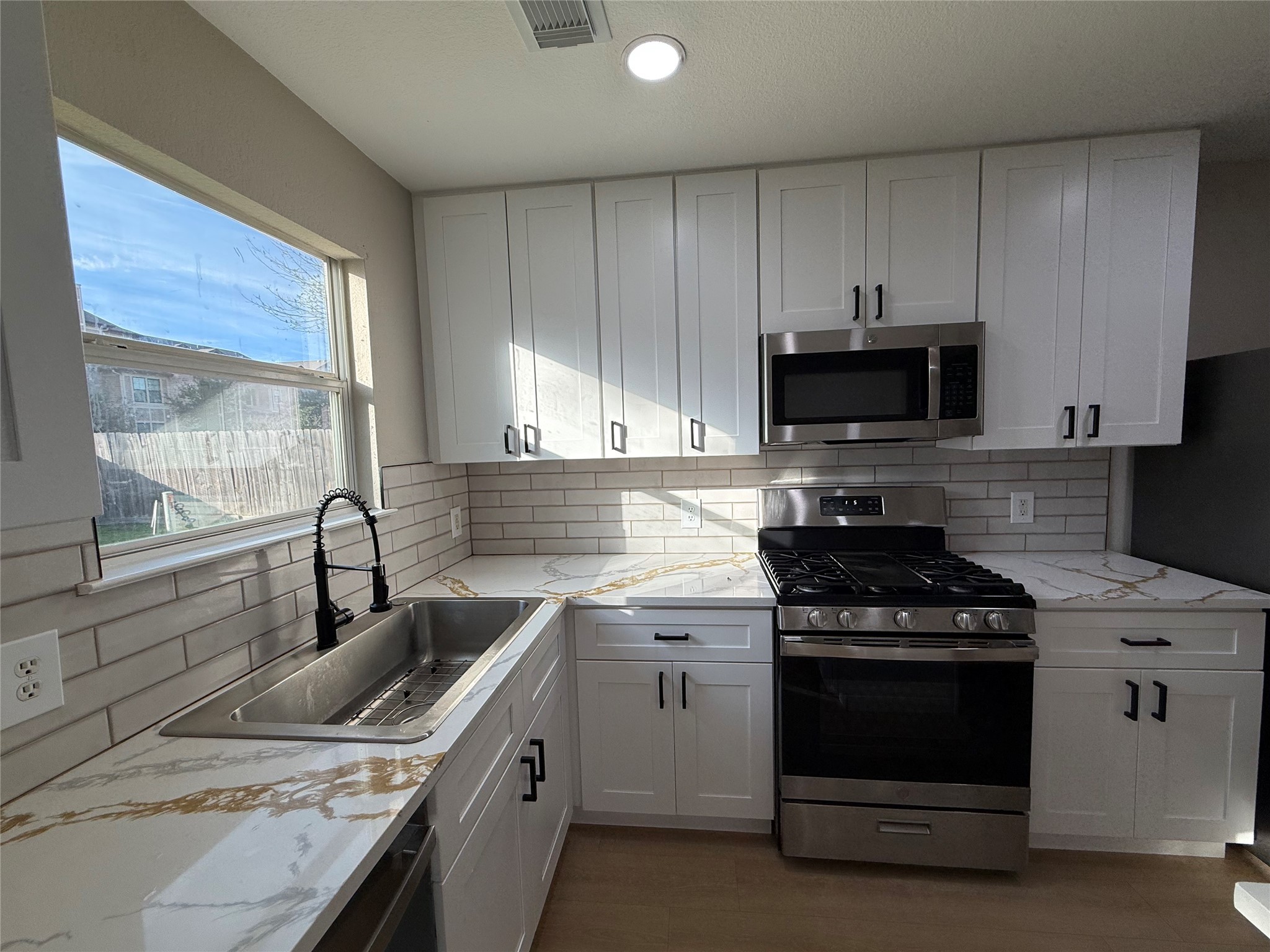 3819 Banks Ridge Lane Katy, TX 77449 - Photo 5 of 19 a kitchen with a sink stove and microwave