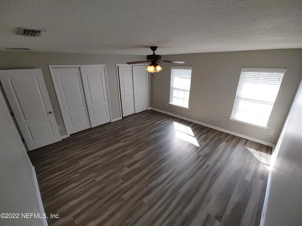 a view of empty room with wooden floor