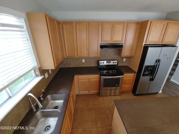 a kitchen with wooden cabinets and a stove top oven