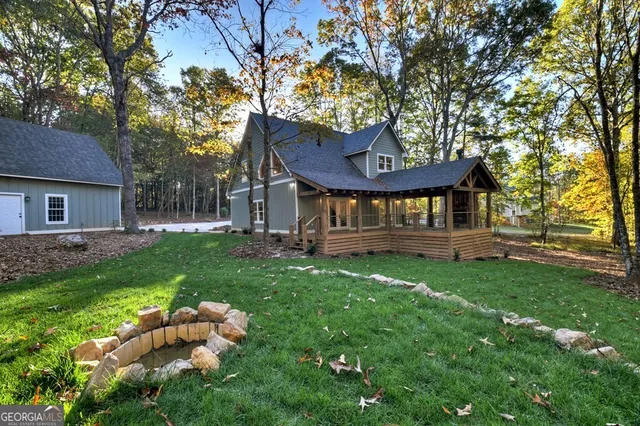 a view of a house with a yard swing and a tree